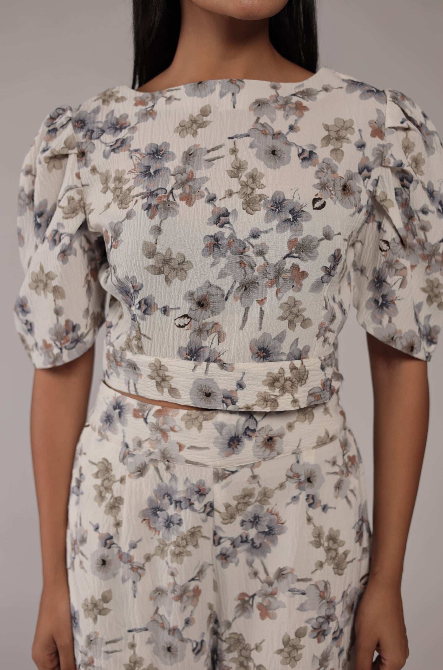 Close-up of the delicate blue and green floral digital print and fabric texture on the cream crop top of the co-ord set.