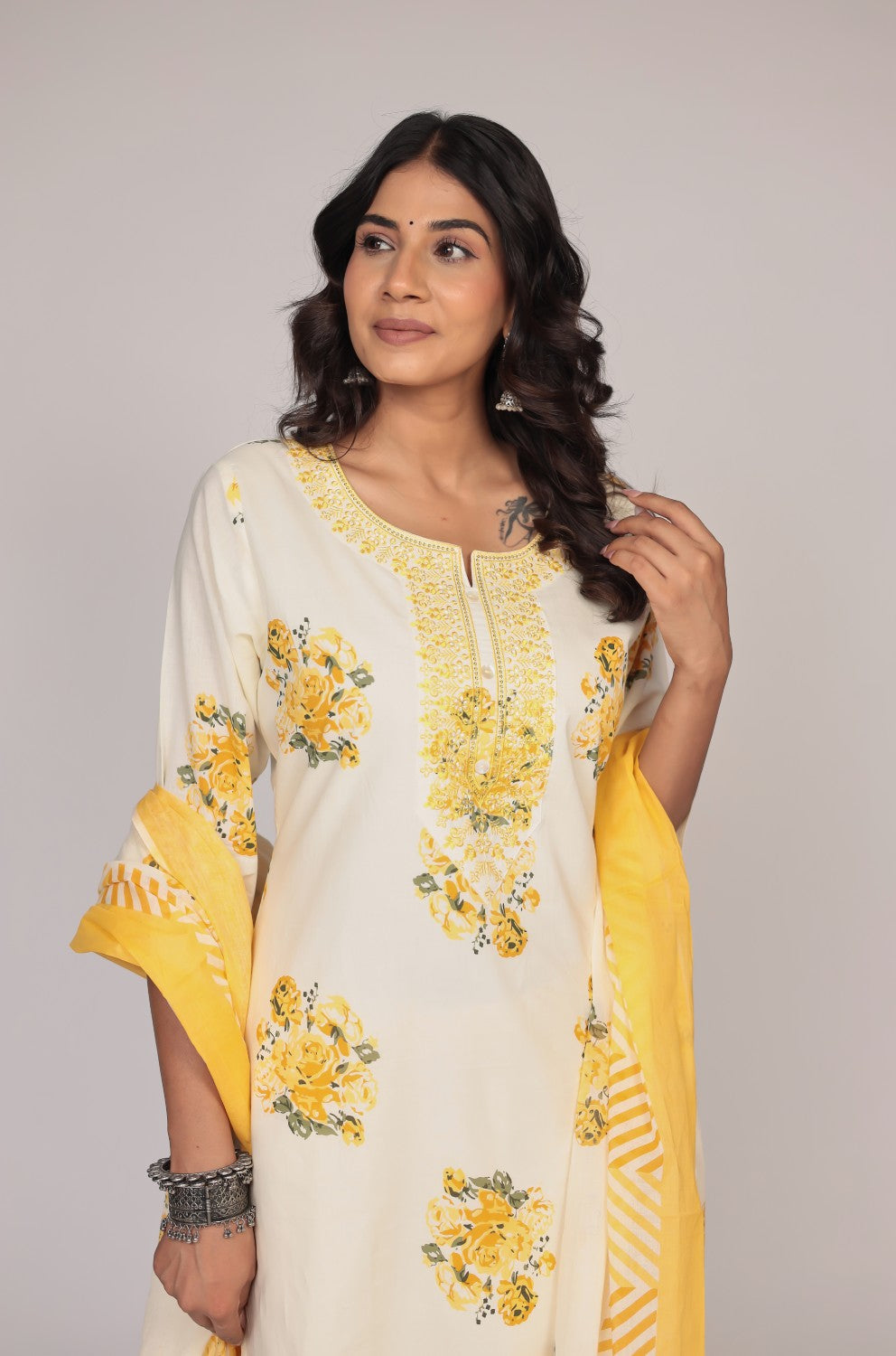 Close-up of the delicate neck embroidery and vibrant Jaipuri print on the cream and yellow kurta, highlighting intricate details.