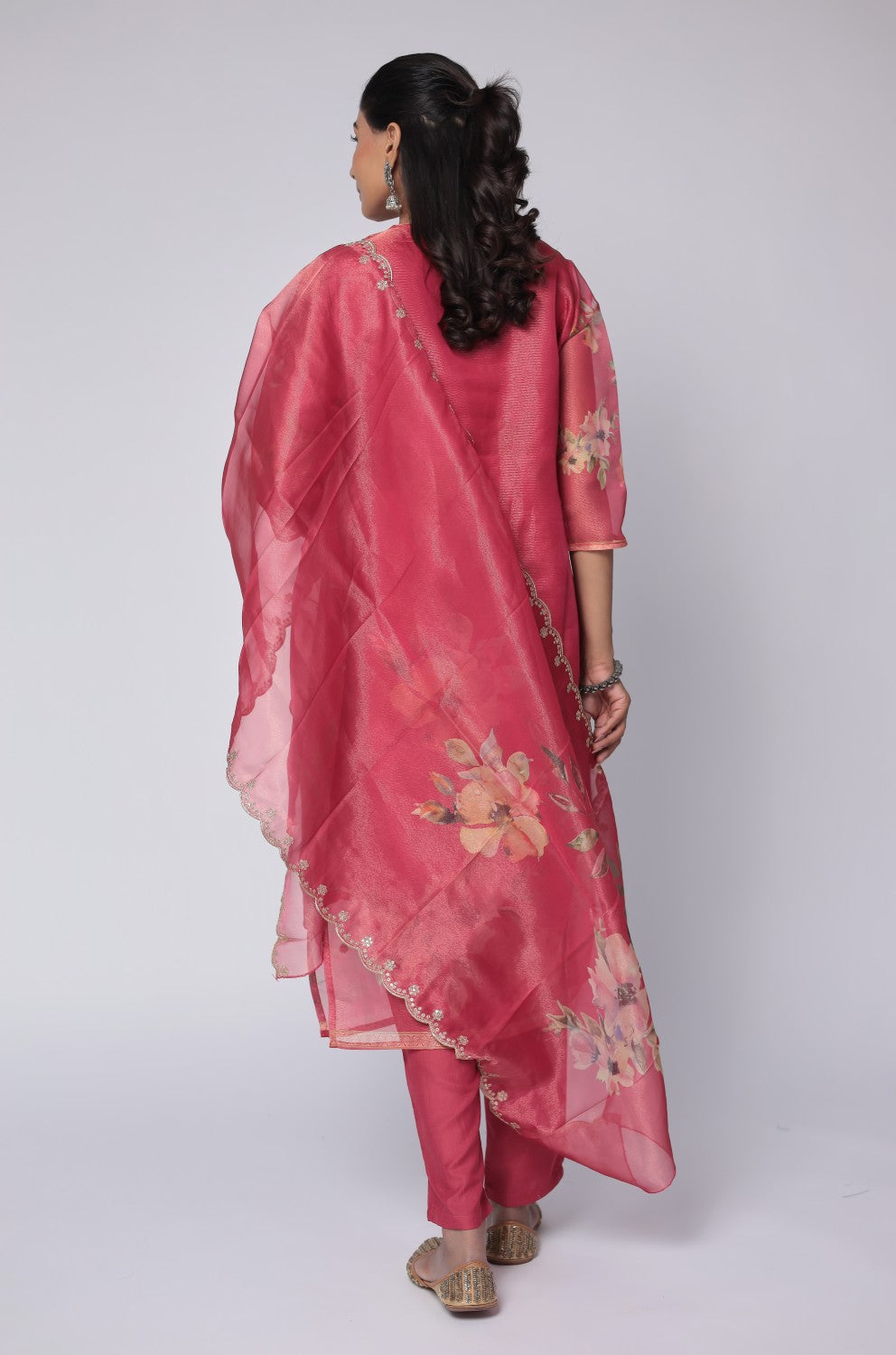 Back view of the deluxe shimmer organza deep pink suit, showing the elegant silhouette and smooth drape of the kurti and soft muslin pants.