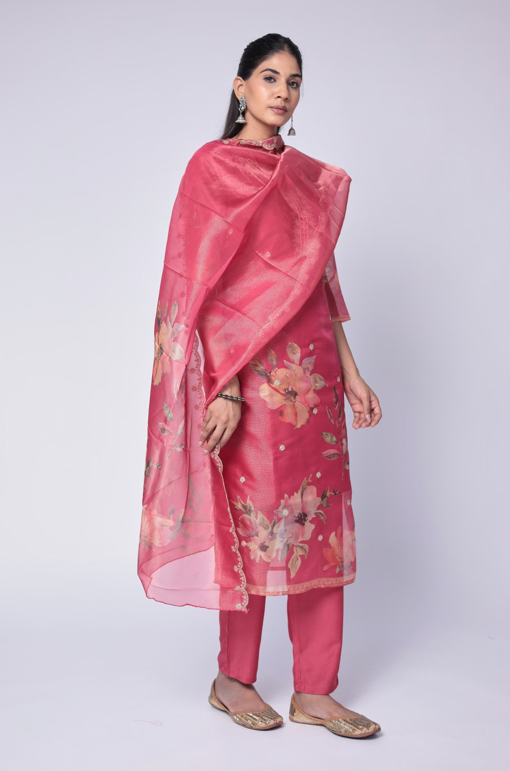 Side profile of model showcasing the comfortable fit and elegant drape of the deluxe shimmer organza deep pink suit with its embroidered dupatta.