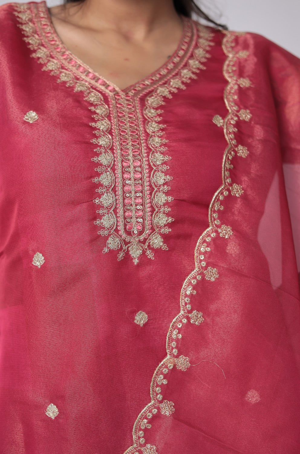 Detailed view of the delicate floral embroidery and soft shimmer on the deep pink organza dupatta, from the suit set.