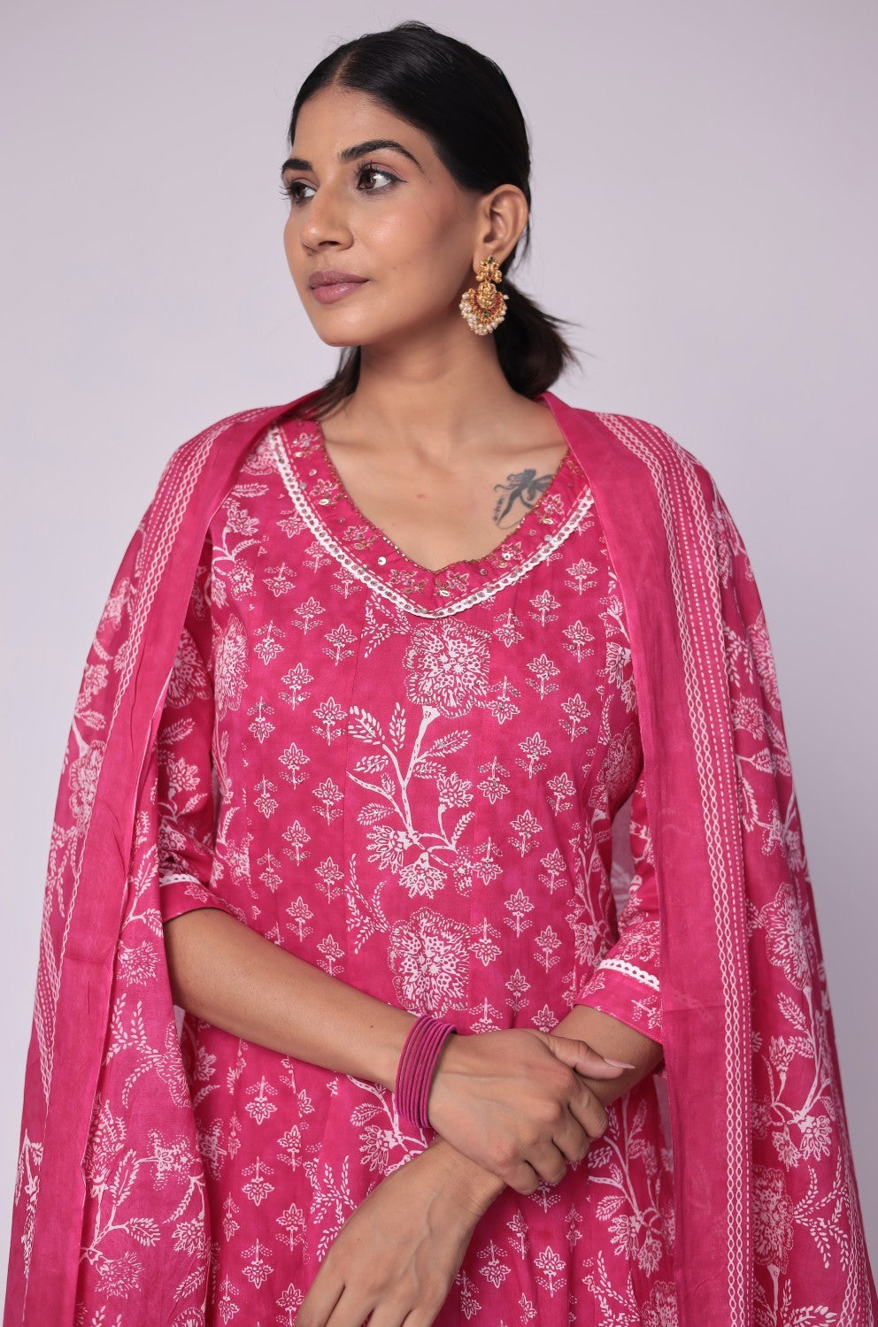 Close-up of the delicate white handwork embroidery on the V-neckline of the fuchsia pink cotton Anarkali kurta, highlighting intricate details.