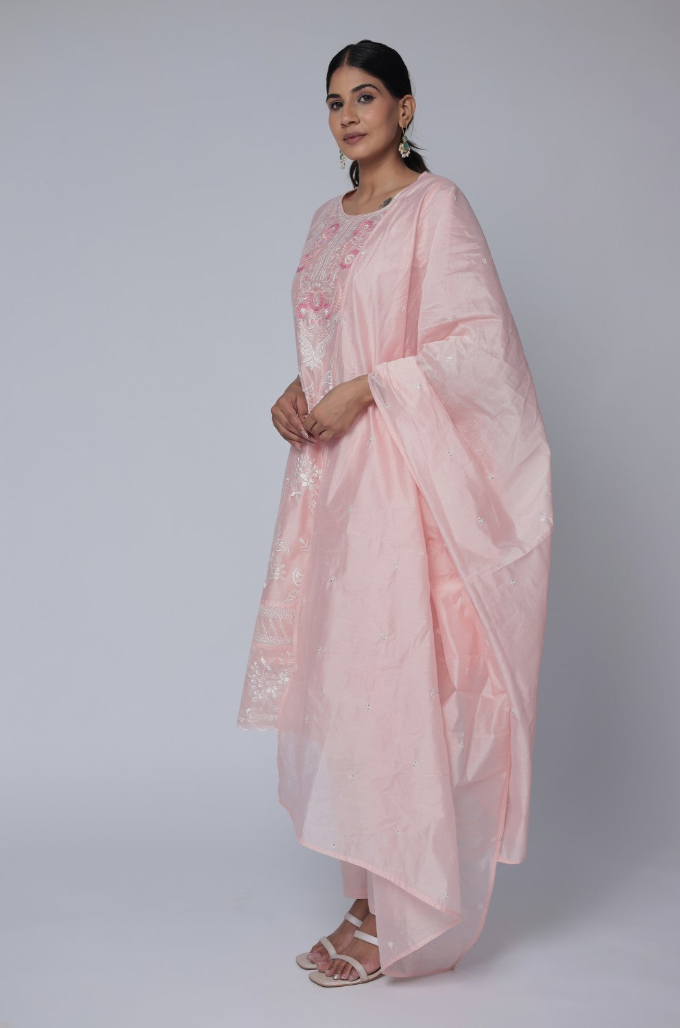 Side profile of model showcasing the comfortable fit and elegant drape of the light peach Chanderi dupatta set with subtle embroidery.