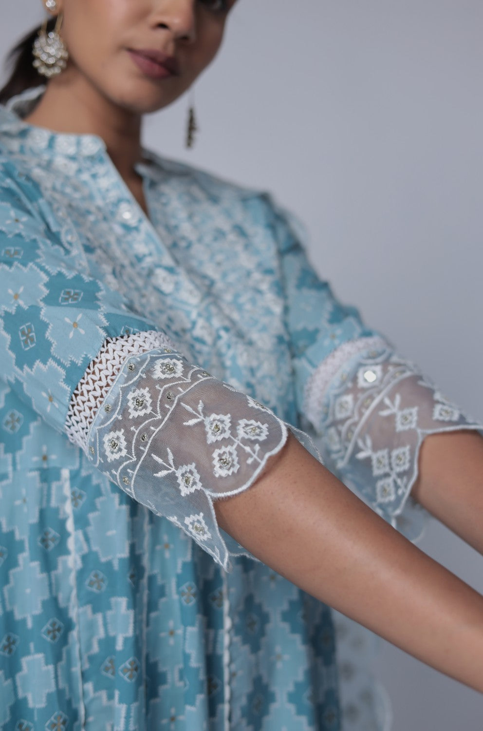 Close-up of the delicate white thread work embroidery on the V-neckline of the ocean blue cotton Anarkali kurta, highlighting intricate details.