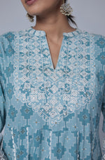 Side profile of model showcasing the voluminous flare and elegant drape of the ocean blue cotton Anarkali dupatta set with white thread work.