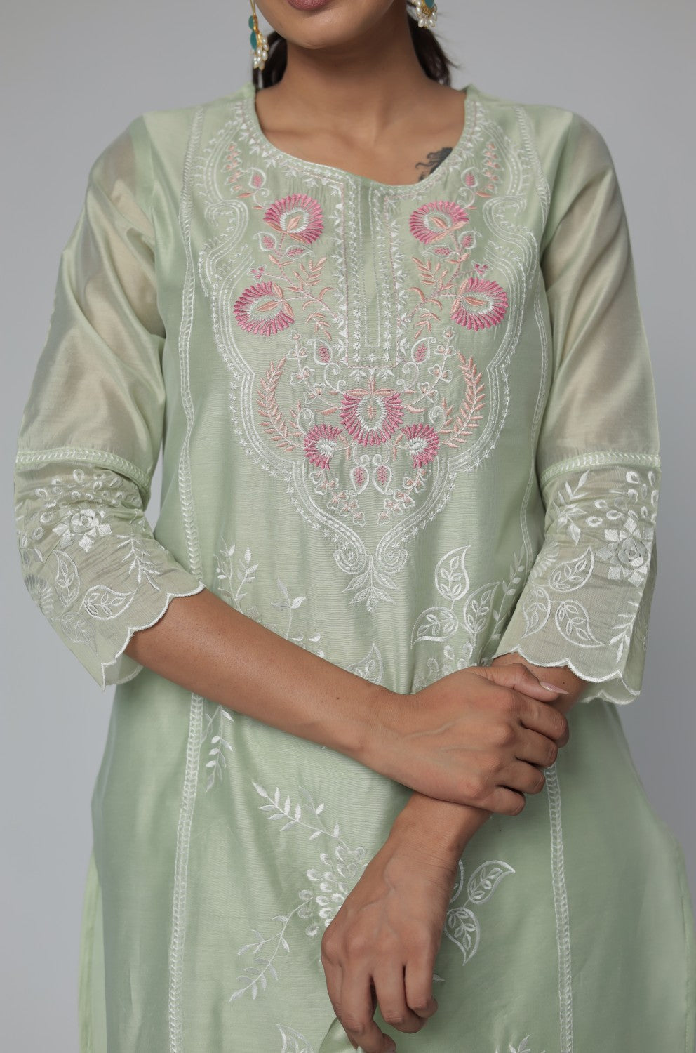 Close-up of the intricate subtle embroidery work on the neckline of the pestal green Chanderi kurti, highlighting delicate detailing.