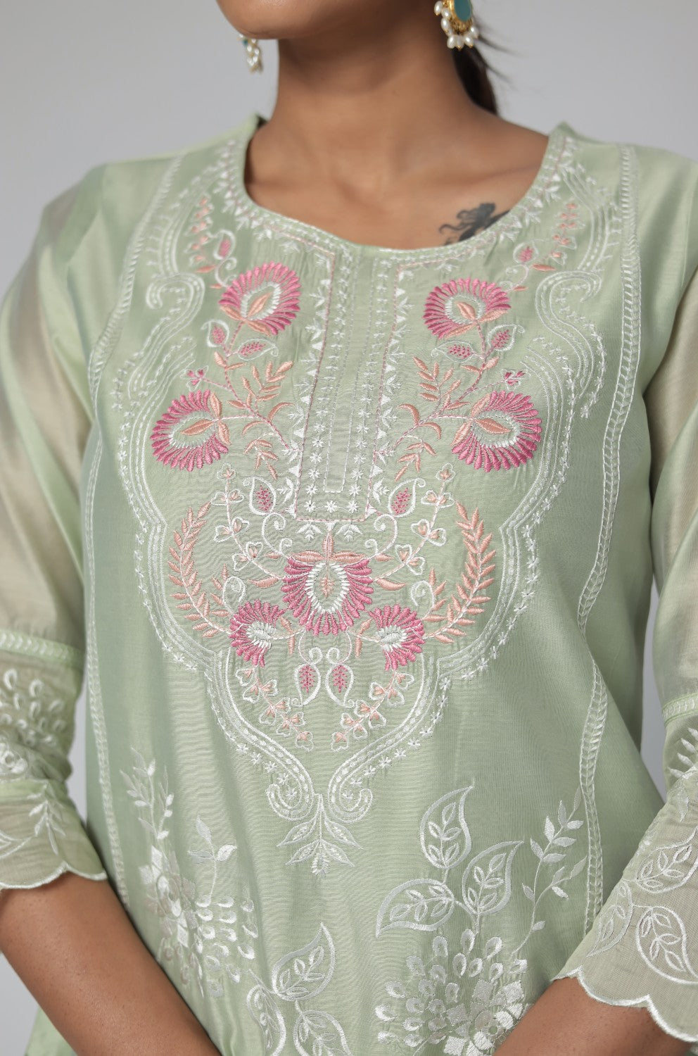 Detailed view of the subtle all-over embroidery work on the sleeve of the pestal green Chanderi kurti.