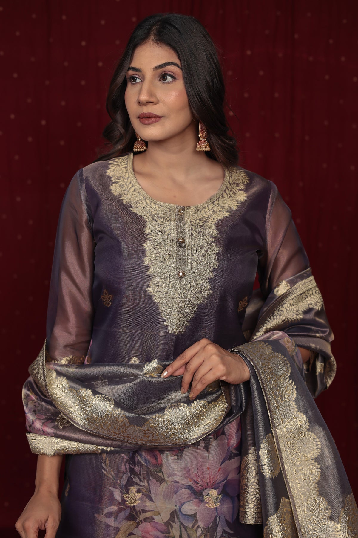 Close-up of the exquisite gold embroidery on the neckline and the woven jacquard floral patterns on the rich purple organza kurti.