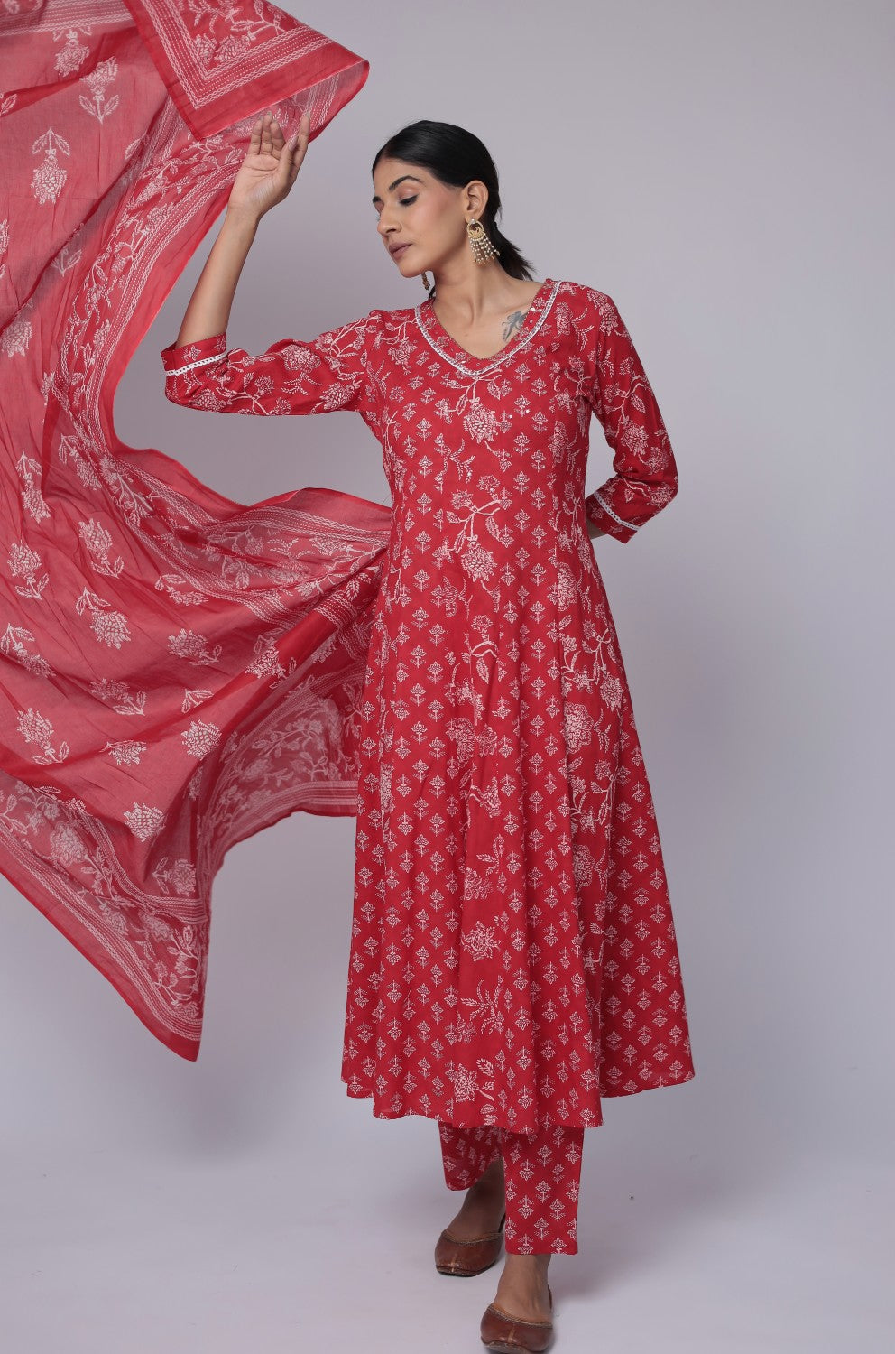 Model gracefully posing in the red cotton Anarkali Jaipuri print dupatta set, showcasing the comfortable movement and elegant flow of the outfit with trailing dupatta.