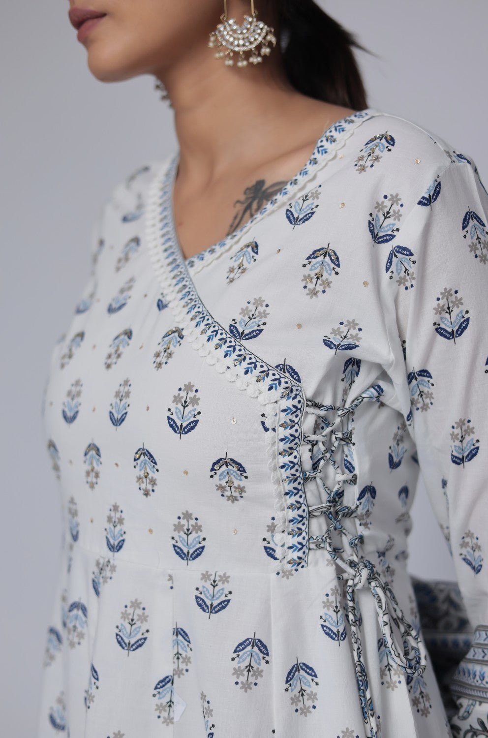 Close-up of the delicate handwork embroidery on the V-neckline of the white and blue cotton Anarkali kurta, highlighting intricate details.