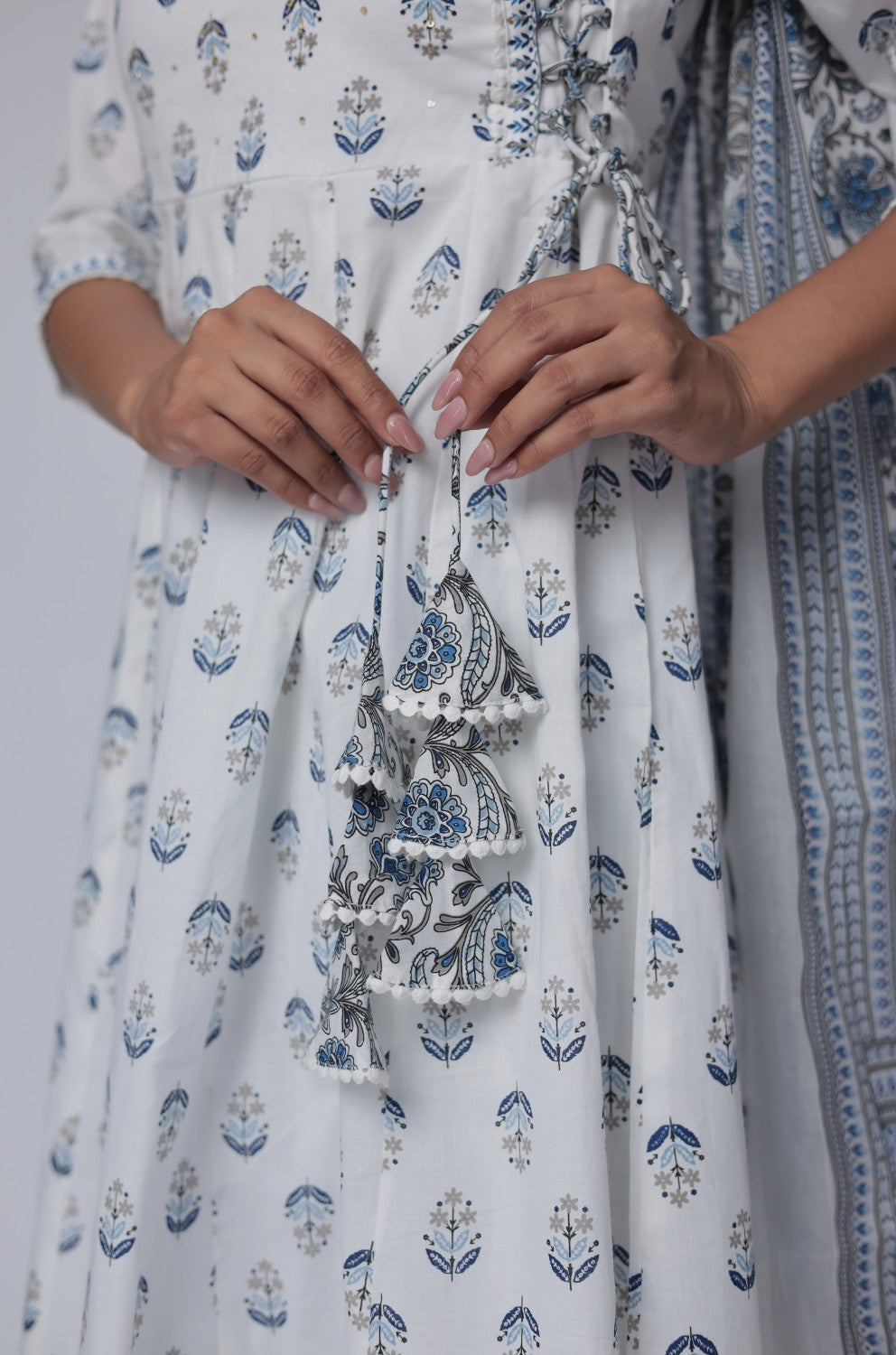 Model adjusting the white and blue Jaipuri print dupatta, showcasing the full front view of the cotton Anarkali set.