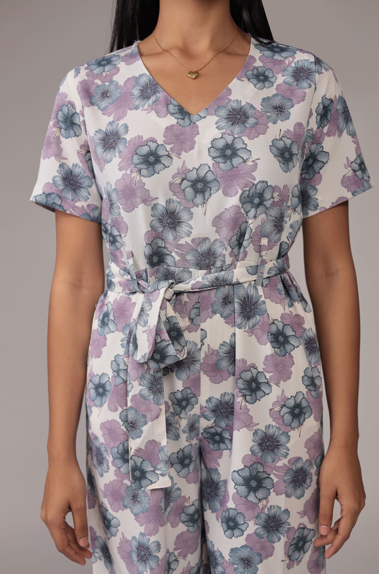 Close-up of the beautiful white top with V-neck, tie-up waist, and intricate pastel floral print, from the co-ord set.