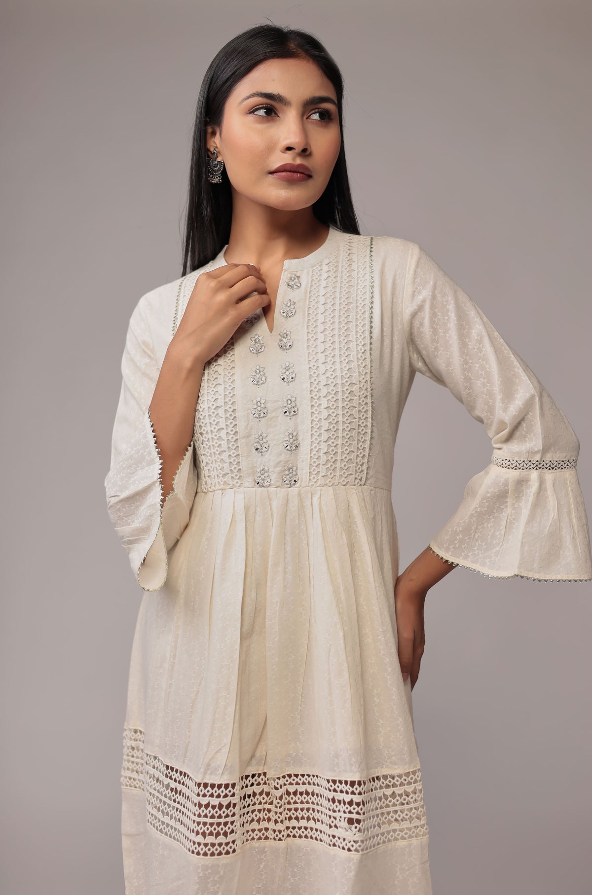 Side profile of model showcasing the layered design and crochet trim of the white cotton dobby dress.