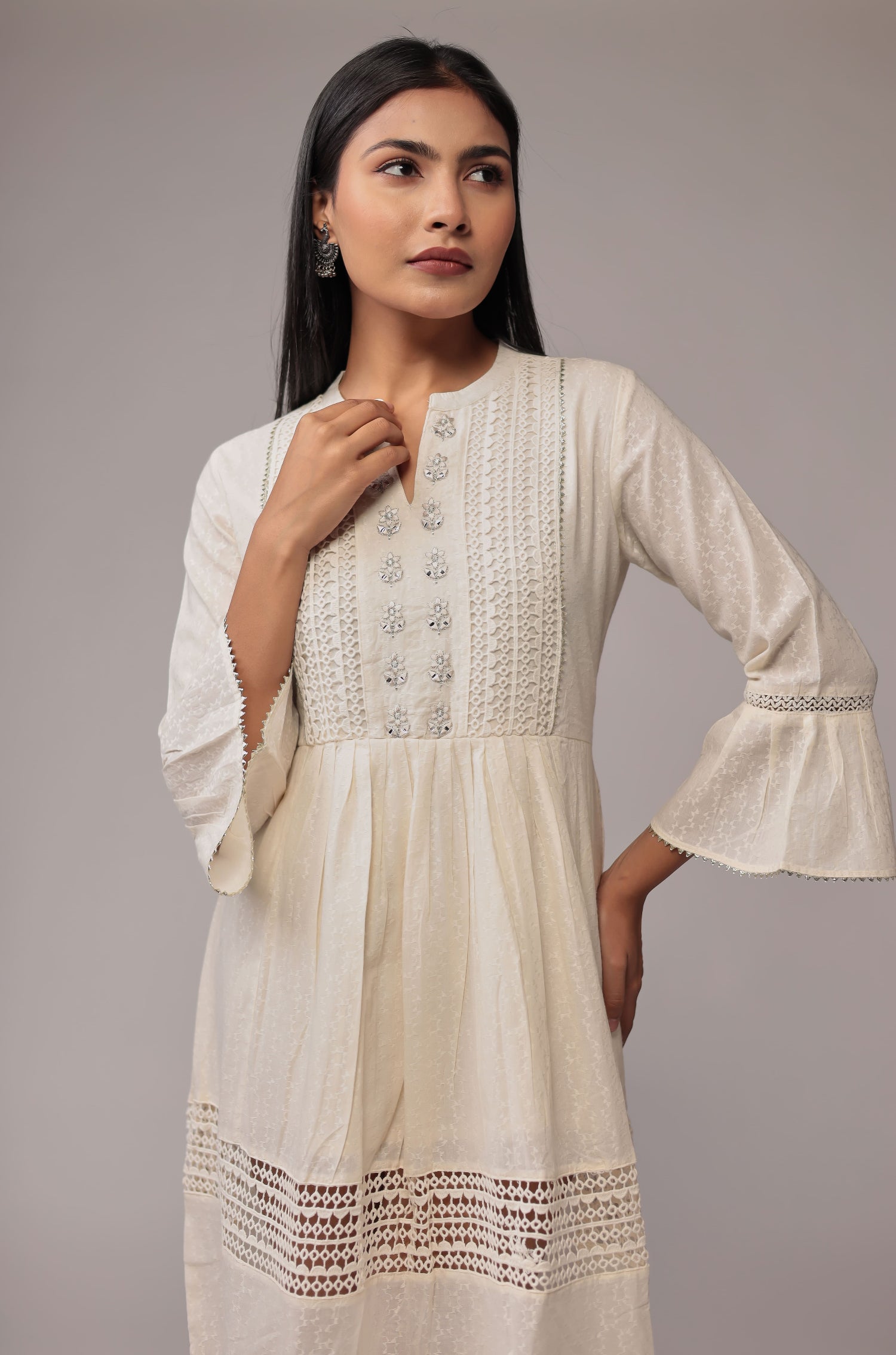 Side profile of model showcasing the layered design and crochet trim of the white cotton dobby dress.