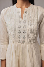 Close-up of the delicate white embroidery on the V-neckline of the cotton dobby dress, highlighting craftsmanship and texture.