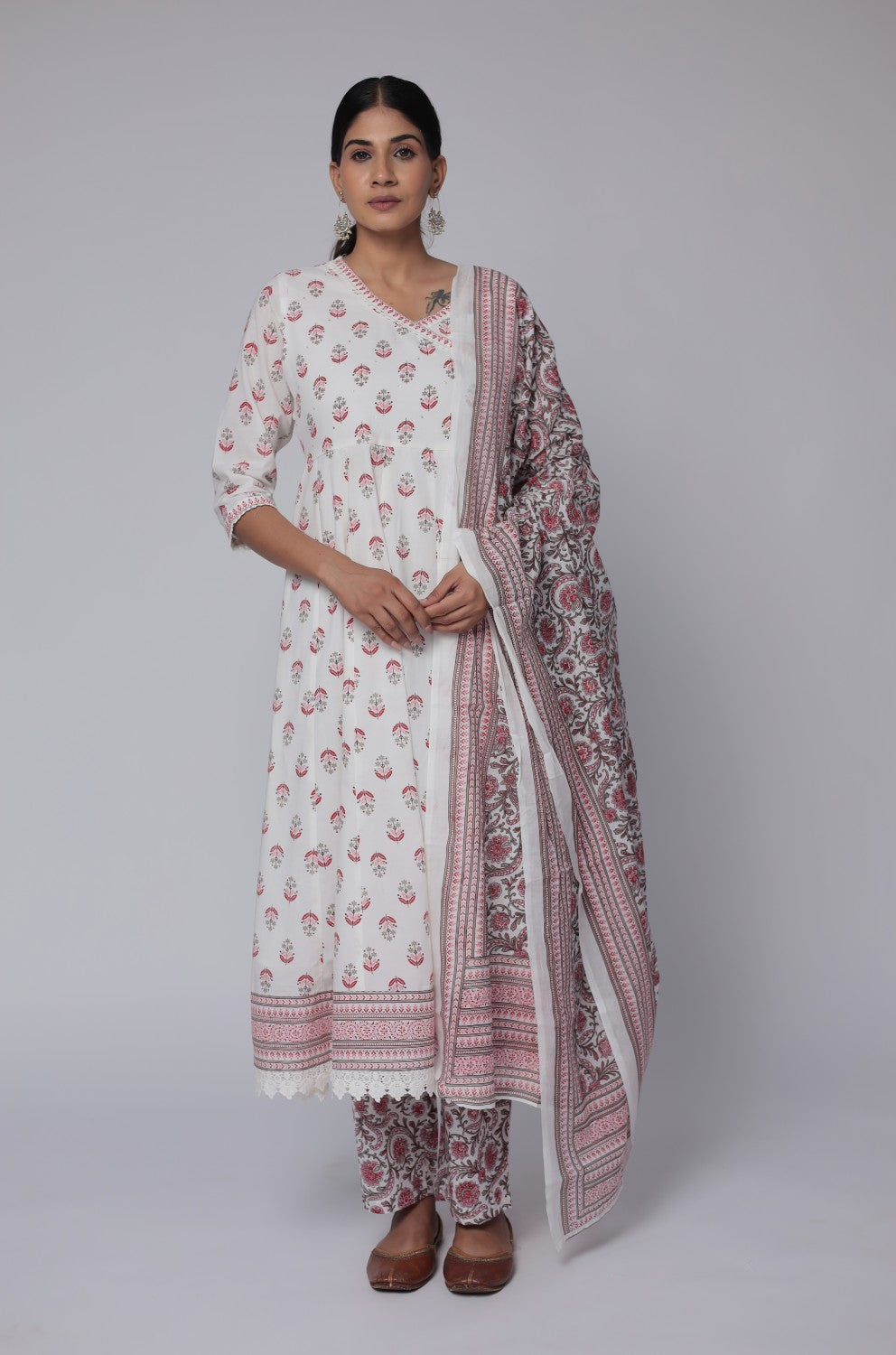 Side profile of model showcasing the voluminous flare and comfortable fit of the white and red cotton Anarkali set with Jaipuri print.