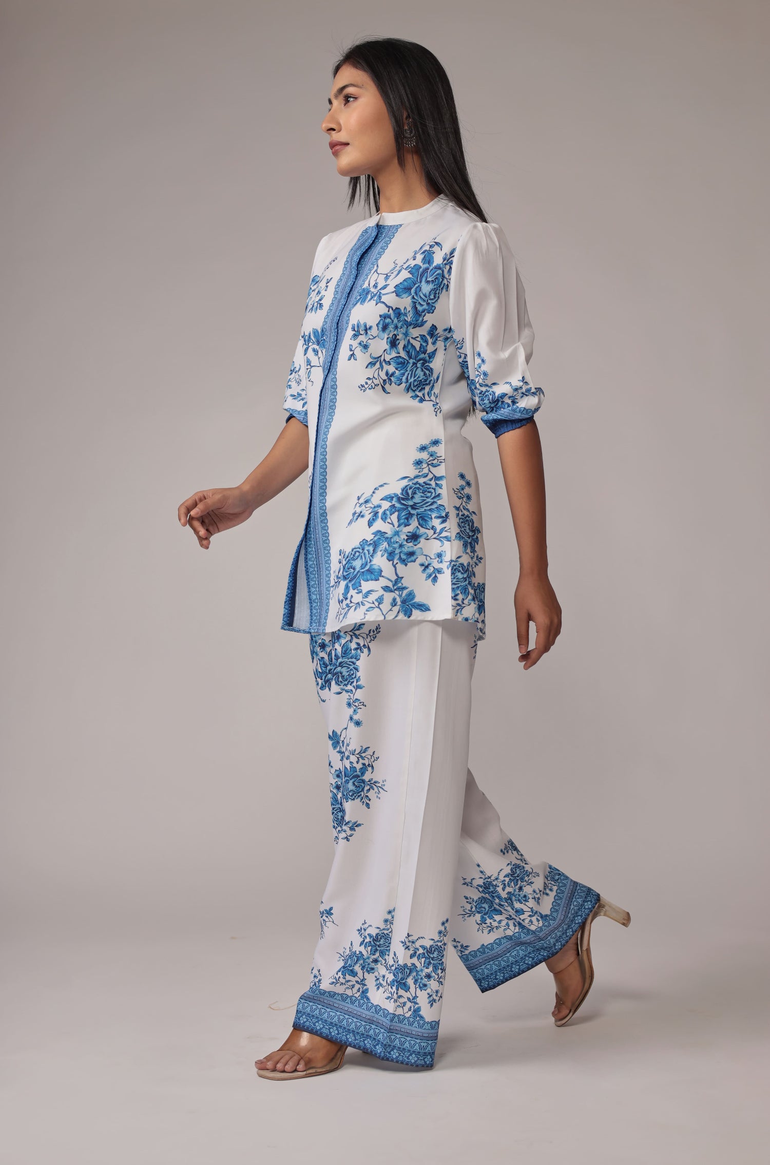 Side profile of model in a walking pose, showcasing the comfortable movement and graceful drape of the white and royal blue digital print co-ord set.