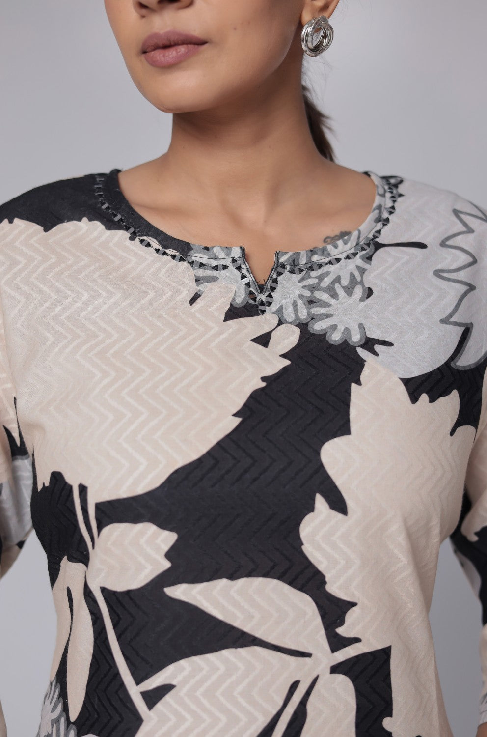 Close-up of the round neckline and striking black and beige abstract print on the front of the premium cotton dobby kurti.