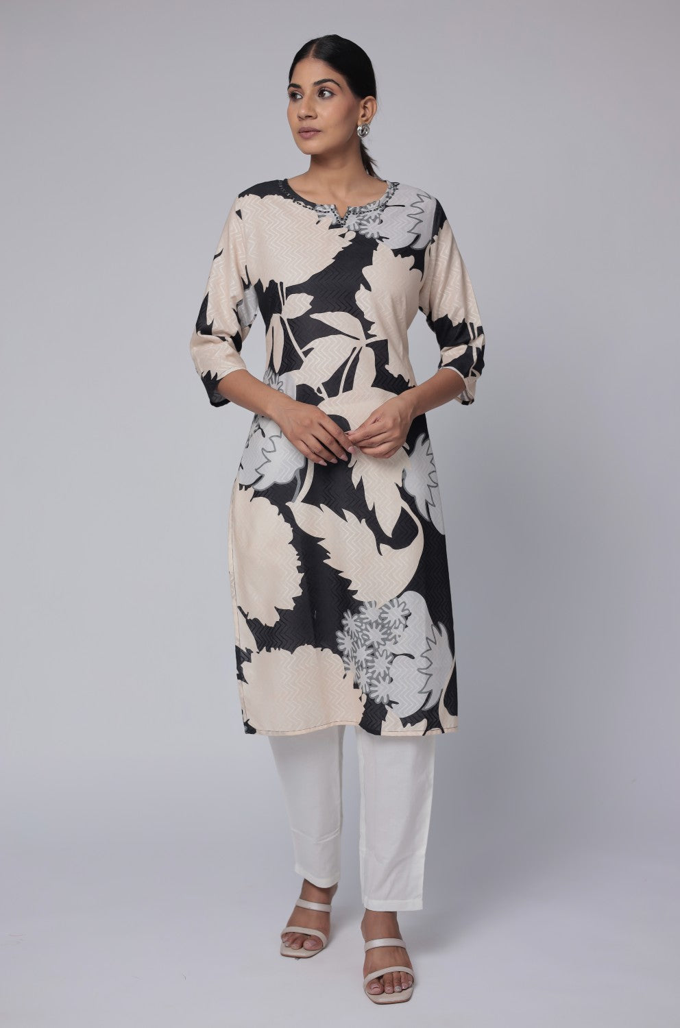 Model wearing a stylish black and beige multicolor premium cotton dobby kurti from The Navra, featuring unique abstract floral prints, paired with white pants. Ideal for comfortable daily or casual ethnic wear.