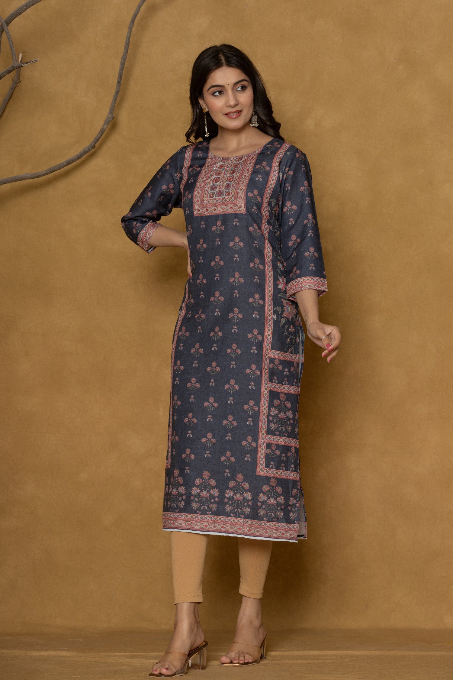 Model wearing a stylish black kurta from The Navra, intricately detailed with handwork on the round neck and featuring unique patterned side panels, paired with light brown leggings. Ideal for comfortable daily or casual ethnic wear.