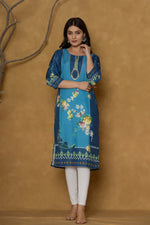 Model in a confident stance, highlighting the full length and overall detailed floral print design of the blue kurta with handwork.

