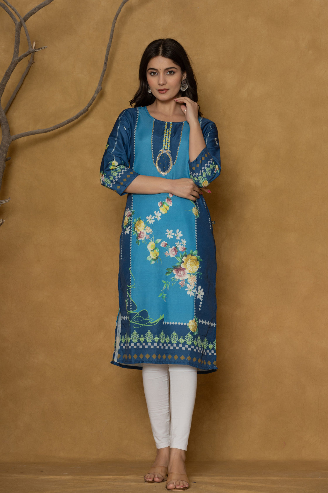 Model in a confident stance, highlighting the full length and overall detailed floral print design of the blue kurta with handwork.

