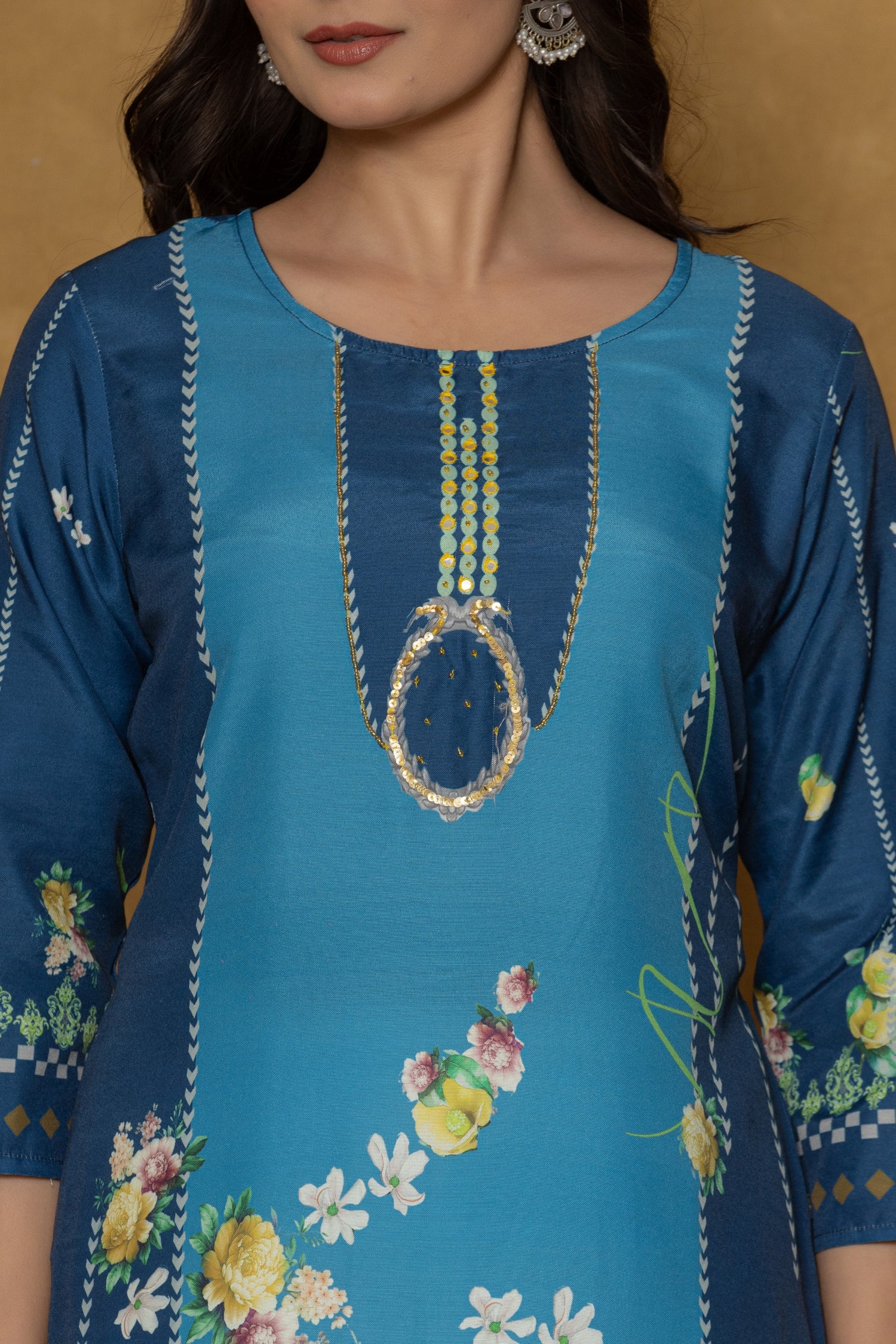 Close-up of the beautiful multi-color handwork embroidery and detailing on the round neckline of the blue kurta, highlighting fine craftsmanship.