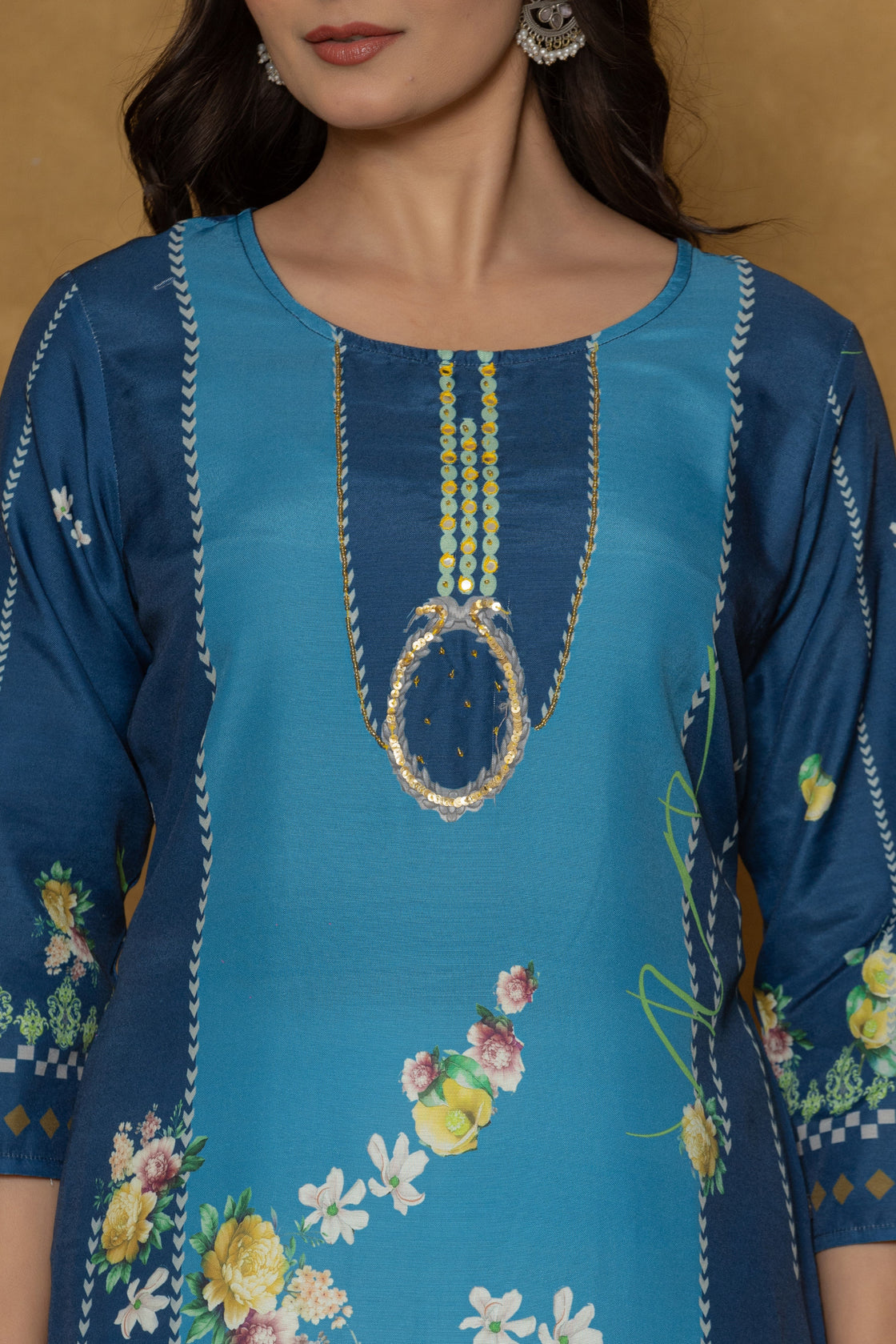 Close-up of the beautiful multi-color handwork embroidery and detailing on the round neckline of the blue kurta, highlighting fine craftsmanship.