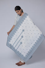 Detailed view of the intricate blue patterns on the off-white cotton jacquard dupatta, showcasing its design and fabric texture.