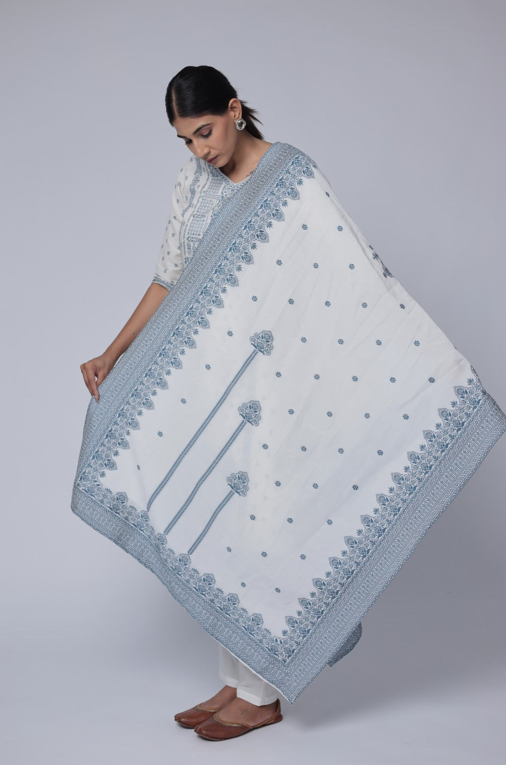 Detailed view of the intricate blue patterns on the off-white cotton jacquard dupatta, showcasing its design and fabric texture.