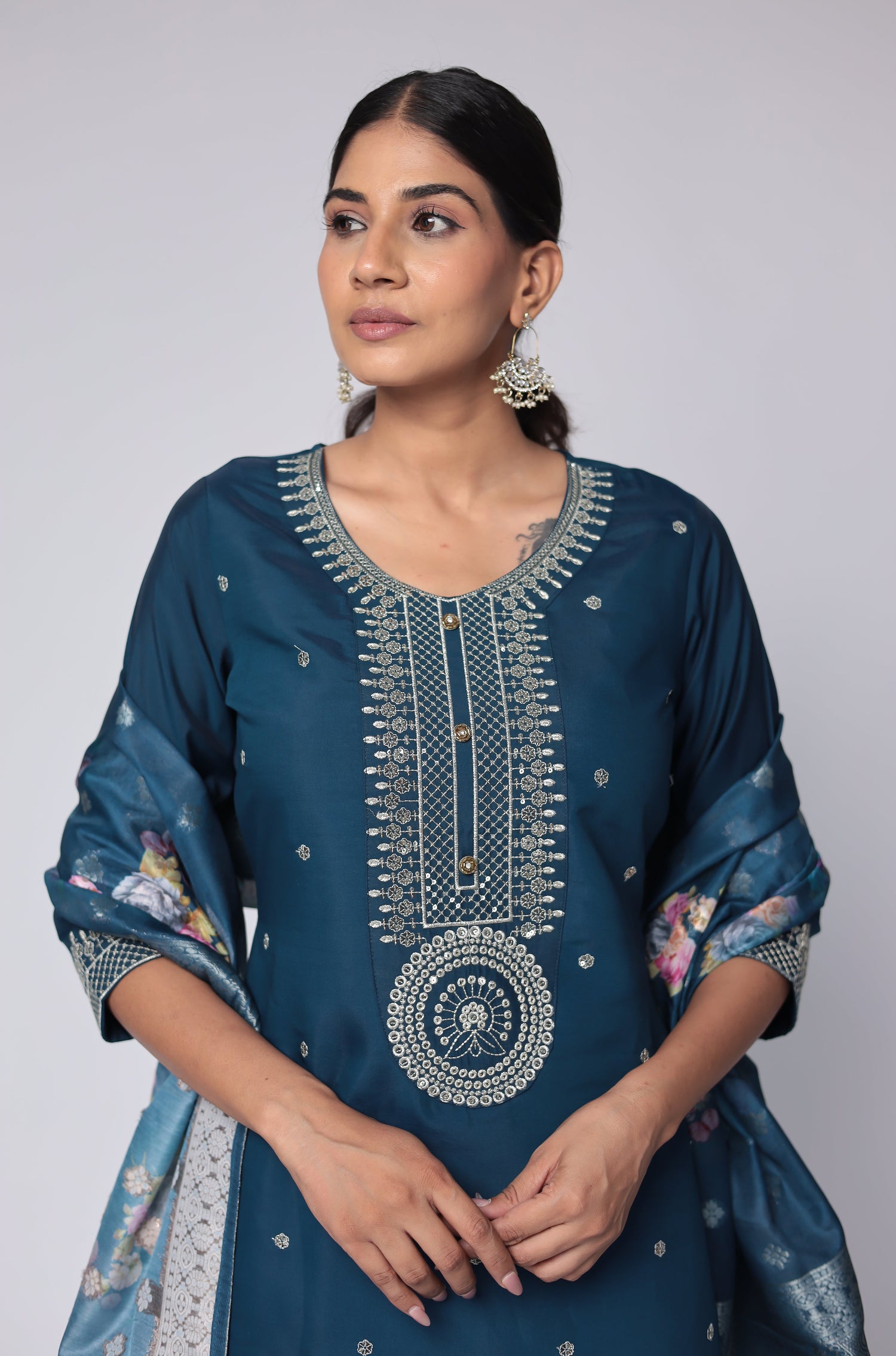 Close-up of the intricate white thread embroidery and shimmering sequins on the neckline and front of the blue soft silk kurta, highlighting fine detailing.