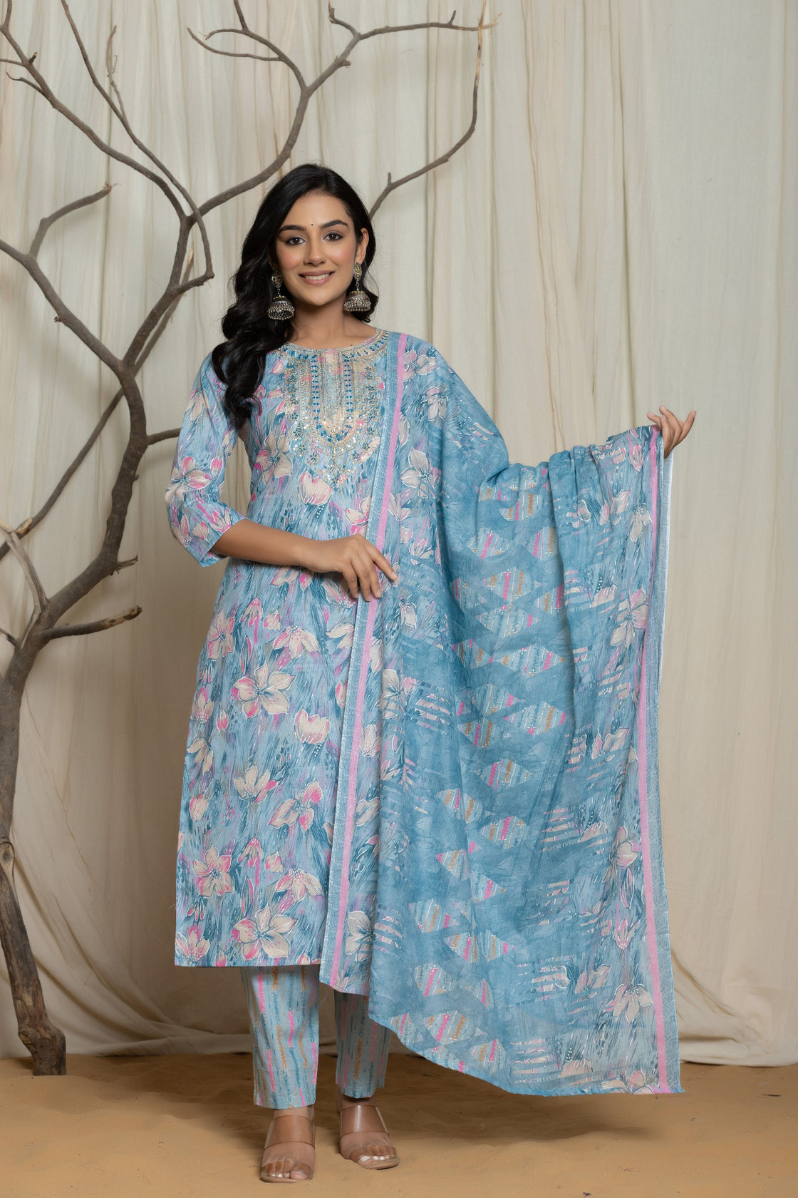 Model wearing a light blue cotton premium mill print dupatta set from The Navra, featuring multicolor abstract prints and delicate embroidery detailing on the neckline. Paired with a flowing printed dupatta and matching pants, ideal for comfortable daily or casual wear.