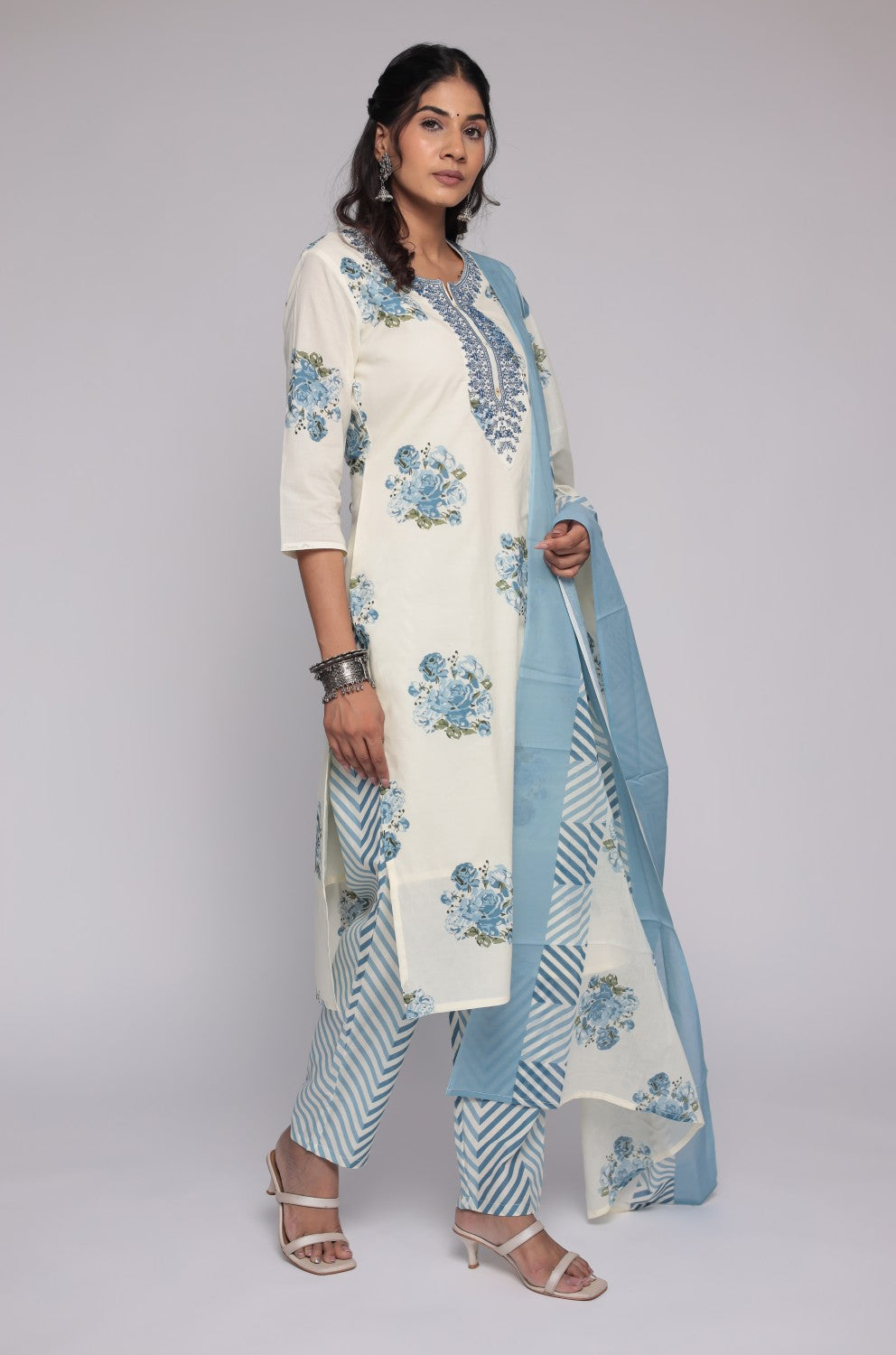 Model in a confident stance, highlighting the full length and vibrant Jaipuri print design of the cream and blue kurta set.