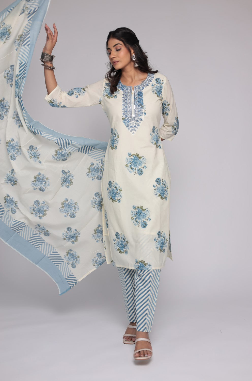 Detailed view of the striped pattern on the mulmul dupatta and the floral print on the pants of the cream and blue Jaipuri set.