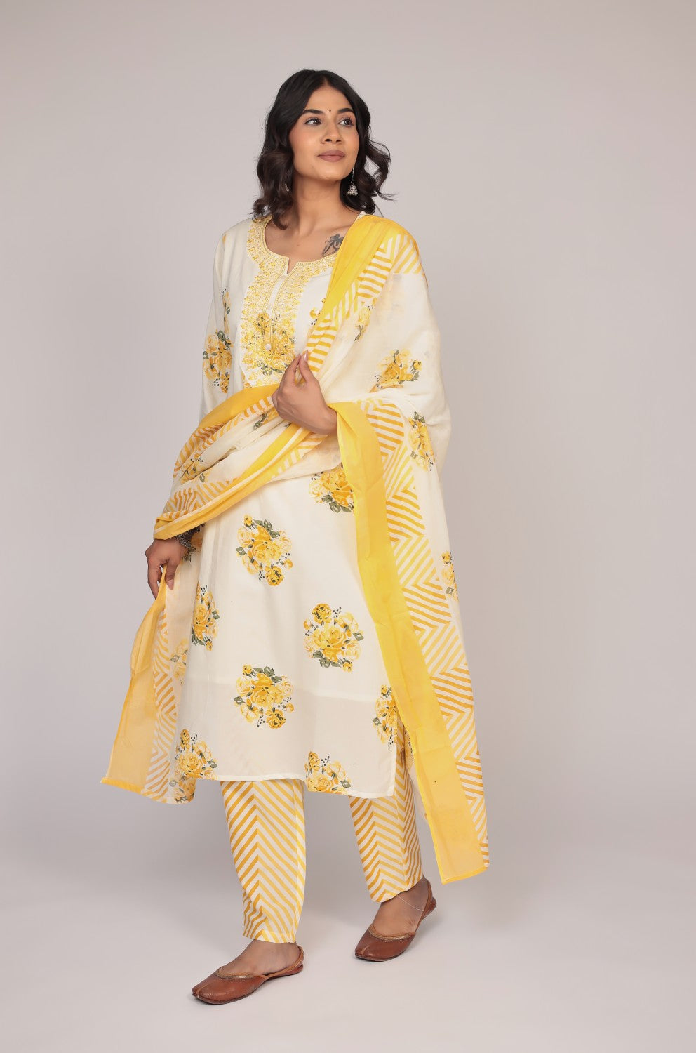 Model in a confident stance, highlighting the full length and vibrant Jaipuri print design of the cream and yellow kurta set.