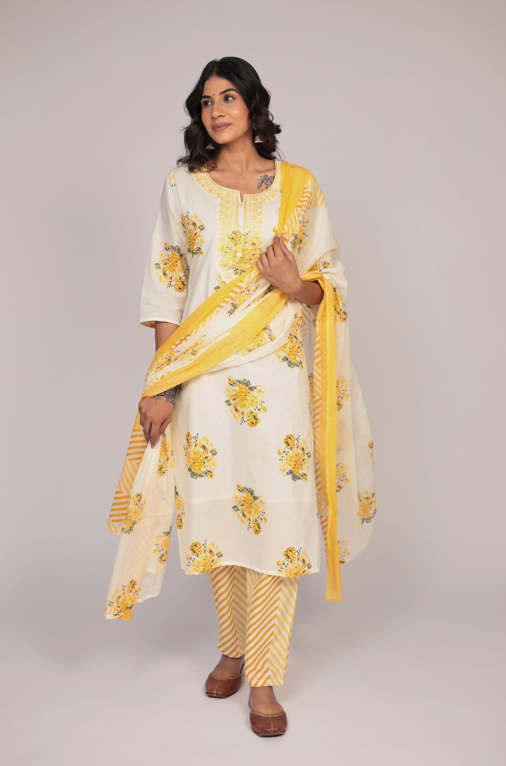 Side profile of model showcasing the comfortable fit and elegant Jaipuri print of the cream and yellow kurta set with mulmul lining.