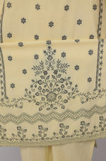 Detailed view of the subtle embroidery and pattern on the hemline of the cream yellow cotton kurta and matching pants.