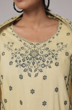 Close-up of the neckline and shoulder area of the cream yellow cotton jacquard kurta, showing the merging embroidery and fabric texture in detail.