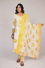 Model gracefully posing in the cream and yellow Jaipuri print kurta set, showcasing the comfortable movement and elegant flow of the mulmul dupatta.

