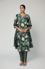 Model in a confident stance, highlighting the full length and vibrant Jaipuri print design of the dark green kurta set.