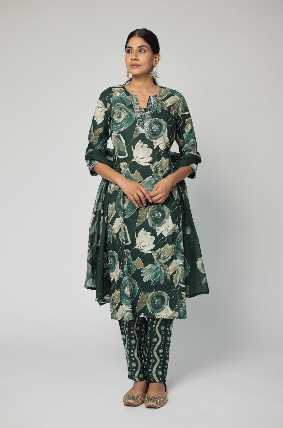 Model in a confident stance, highlighting the full length and vibrant Jaipuri print design of the dark green kurta set.