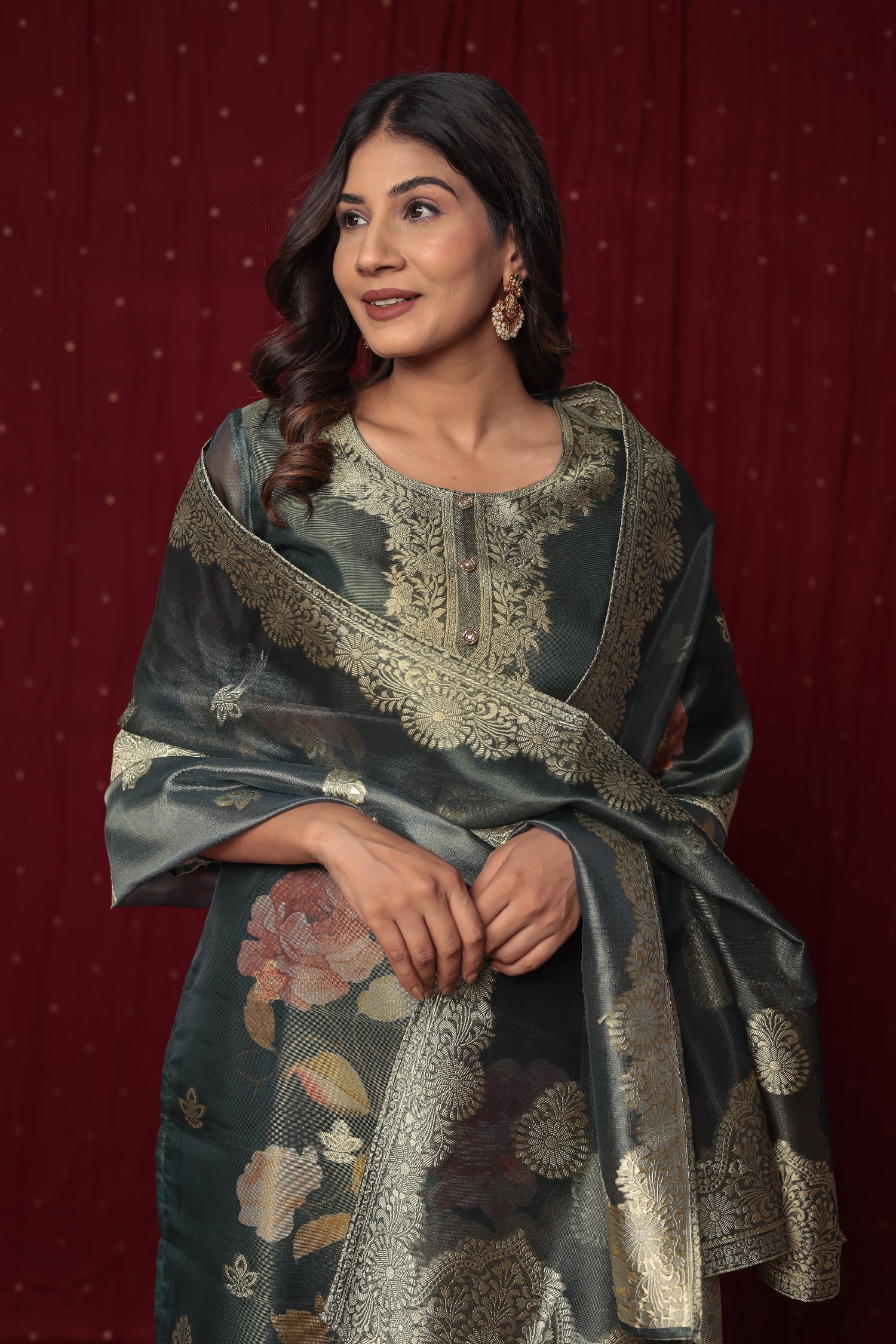 Close-up of the rich gold jacquard weaving and delicate embroidery on the neckline of the dark green kurti.