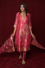 Flat lay arrangement of the complete deluxe jacquard organza pink suit set, highlighting the rich fabric texture and woven patterns of the kurti and matching dupatta.
