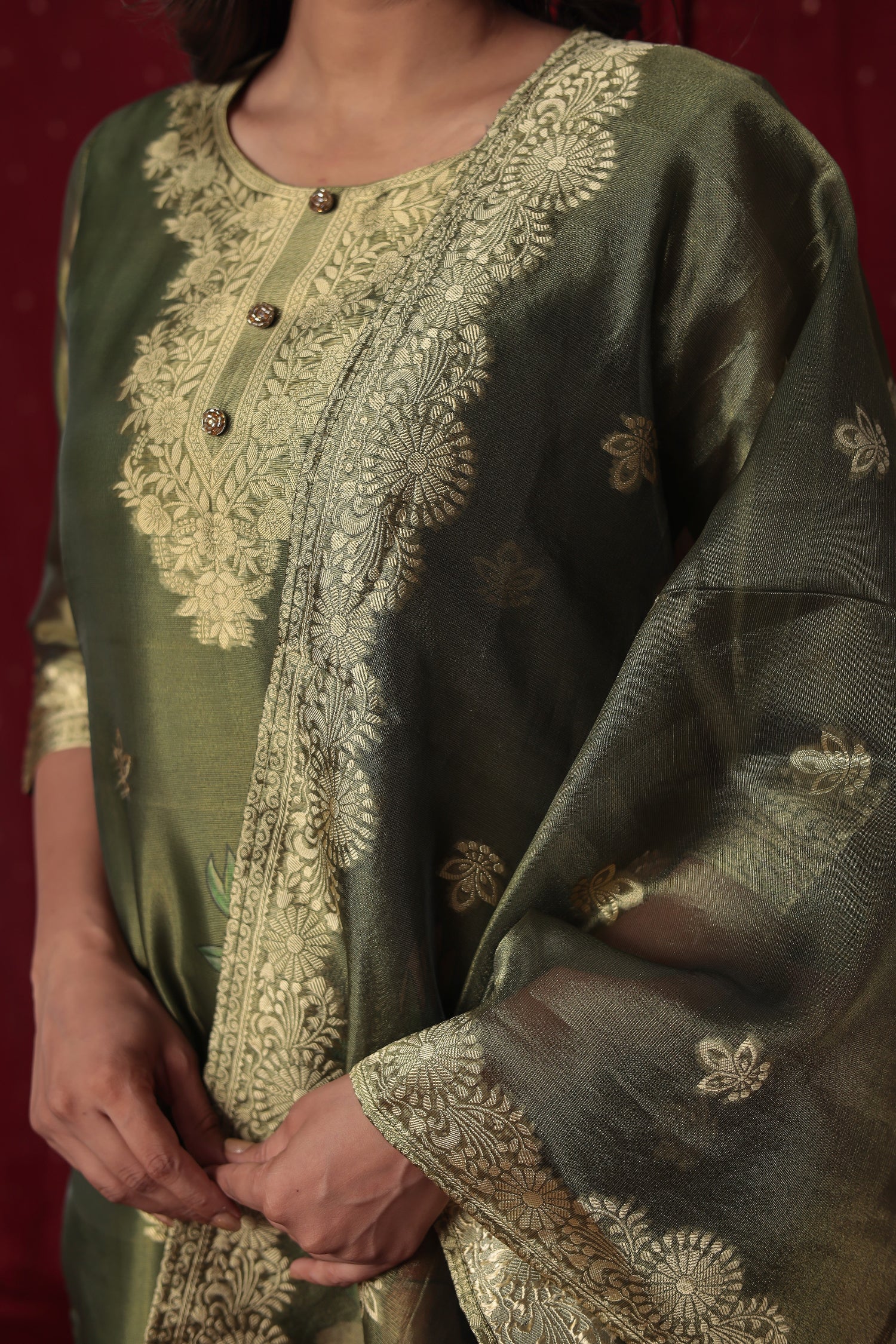 Detailed view of the luxurious olive green jacquard organza dupatta with rich gold woven designs and subtle floral prints, complementing the suit.