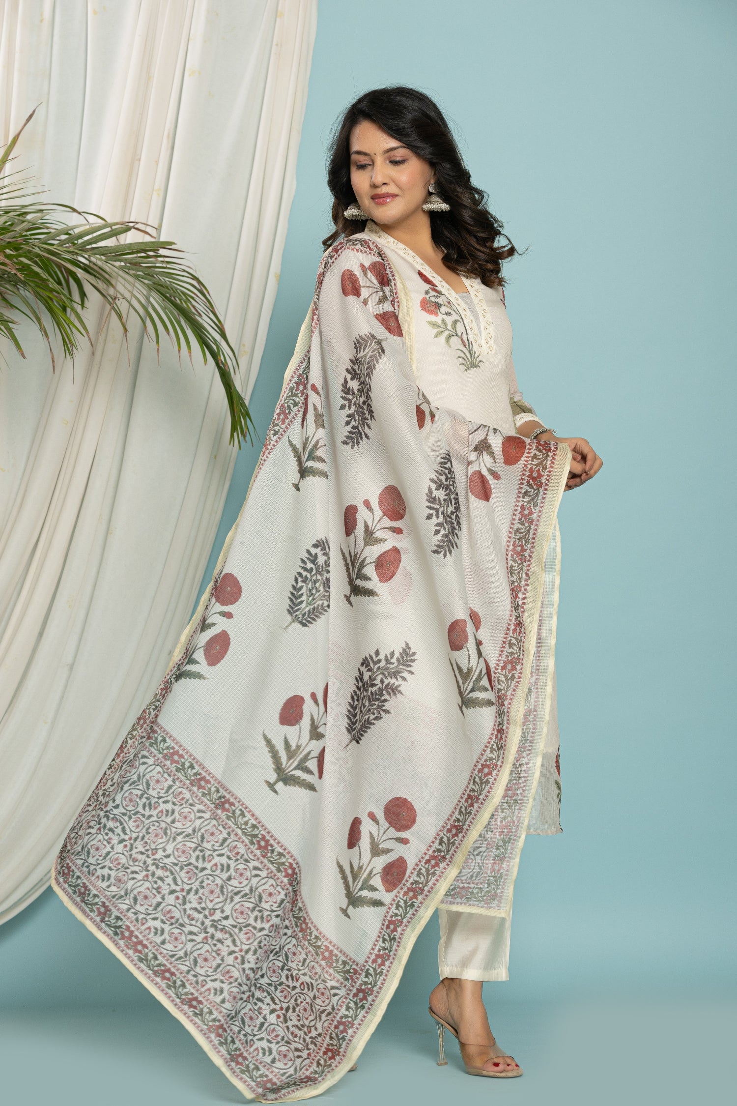 Side profile of model showcasing the light and airy feel of the white Kota Doria suit and dupatta.