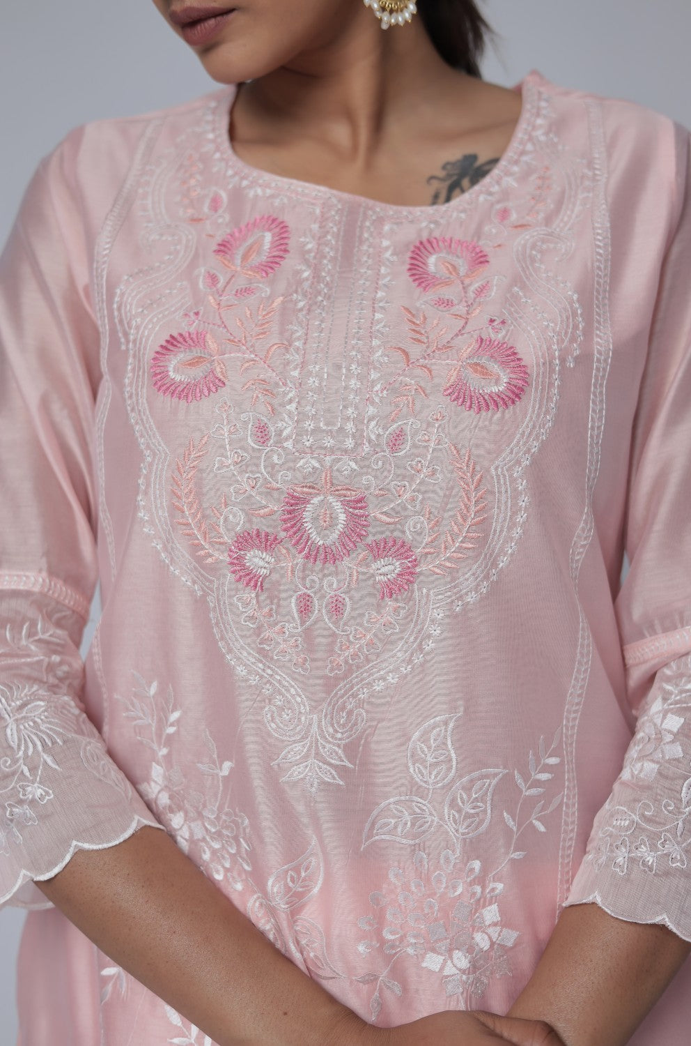 Close-up of the intricate subtle embroidery work on the neckline of the light peach Chanderi kurta, highlighting delicate detailing.