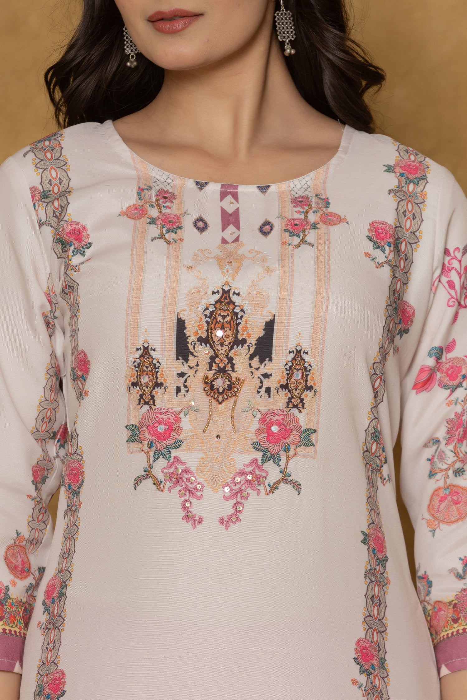 Close-up of the beautiful multi-color handwork embroidery and intricate patterns on the round neckline of the light pink kurta, highlighting fine craftsmanship.
