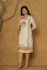 Model wearing a light yellow kurta from The Navra, featuring intricate handwork on the round neck and colorful floral prints on the hem and sleeves, paired with light beige leggings. Ideal for comfortable daily or casual ethnic wear.