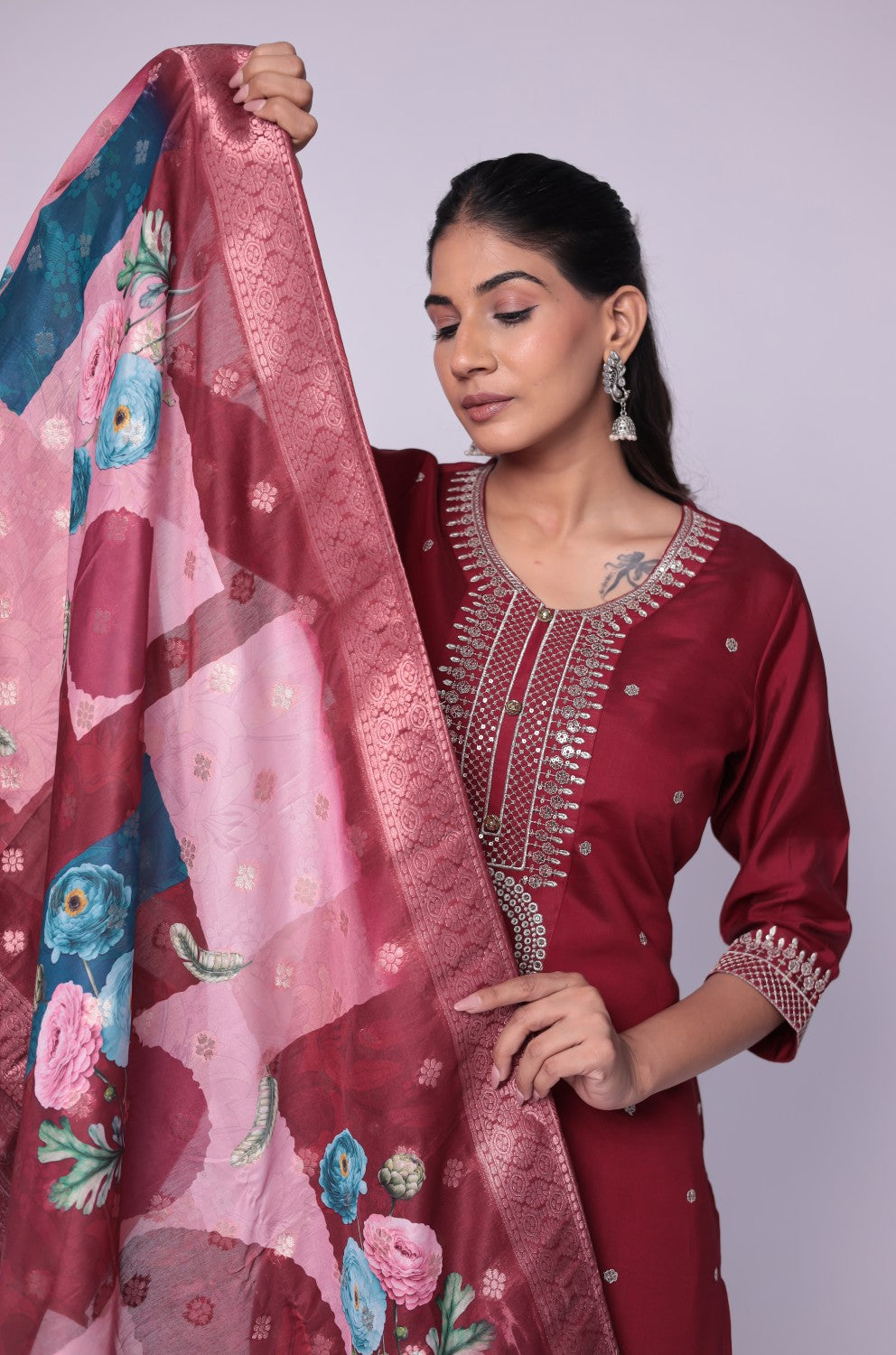 Side profile of model showcasing the elegant drape of the printed jacquard dupatta and the flattering fit of the maroon soft silk suit set.