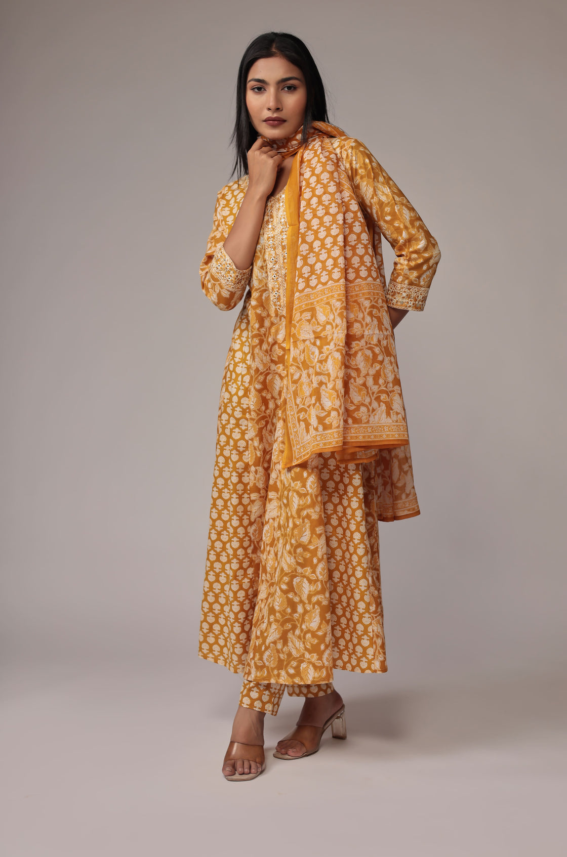Side profile of model showcasing the voluminous flare and elegant drape of the printed mustard yellow Anarkali dupatta set.